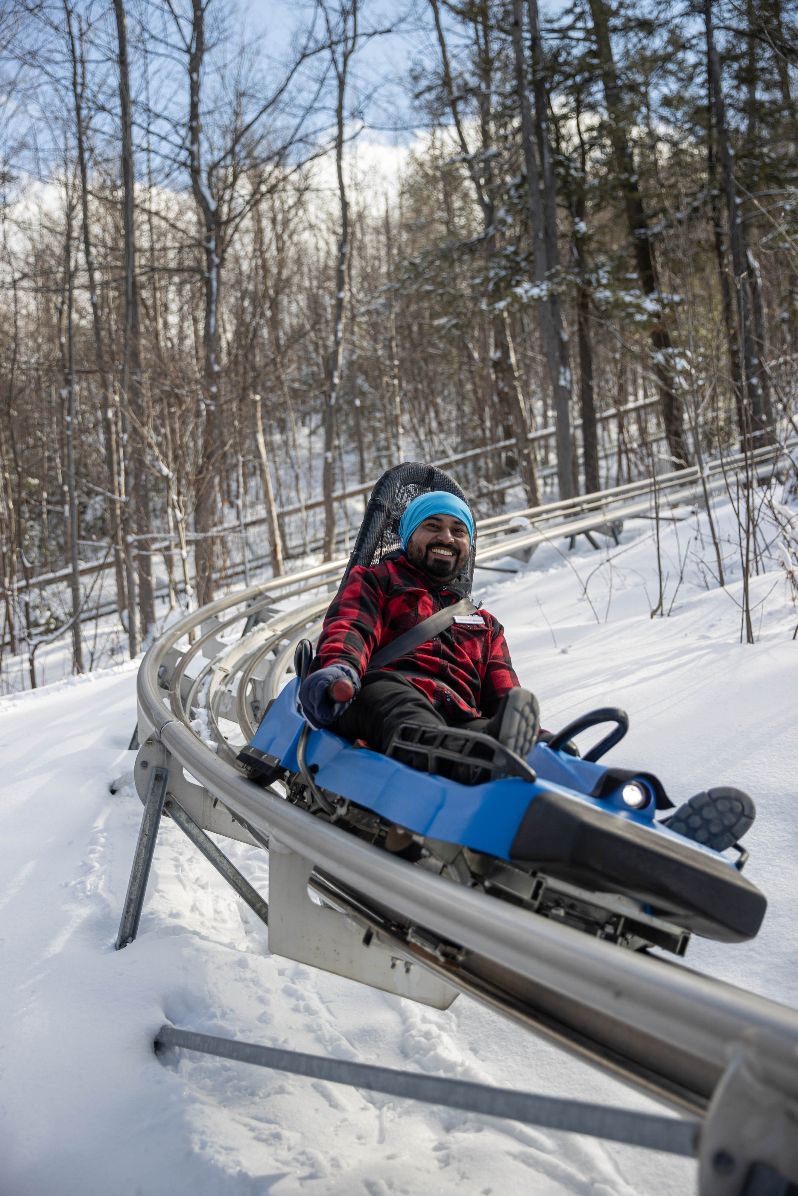 Man racing down the Ridge Runner Mountain Coaster on a Winter afternoon.