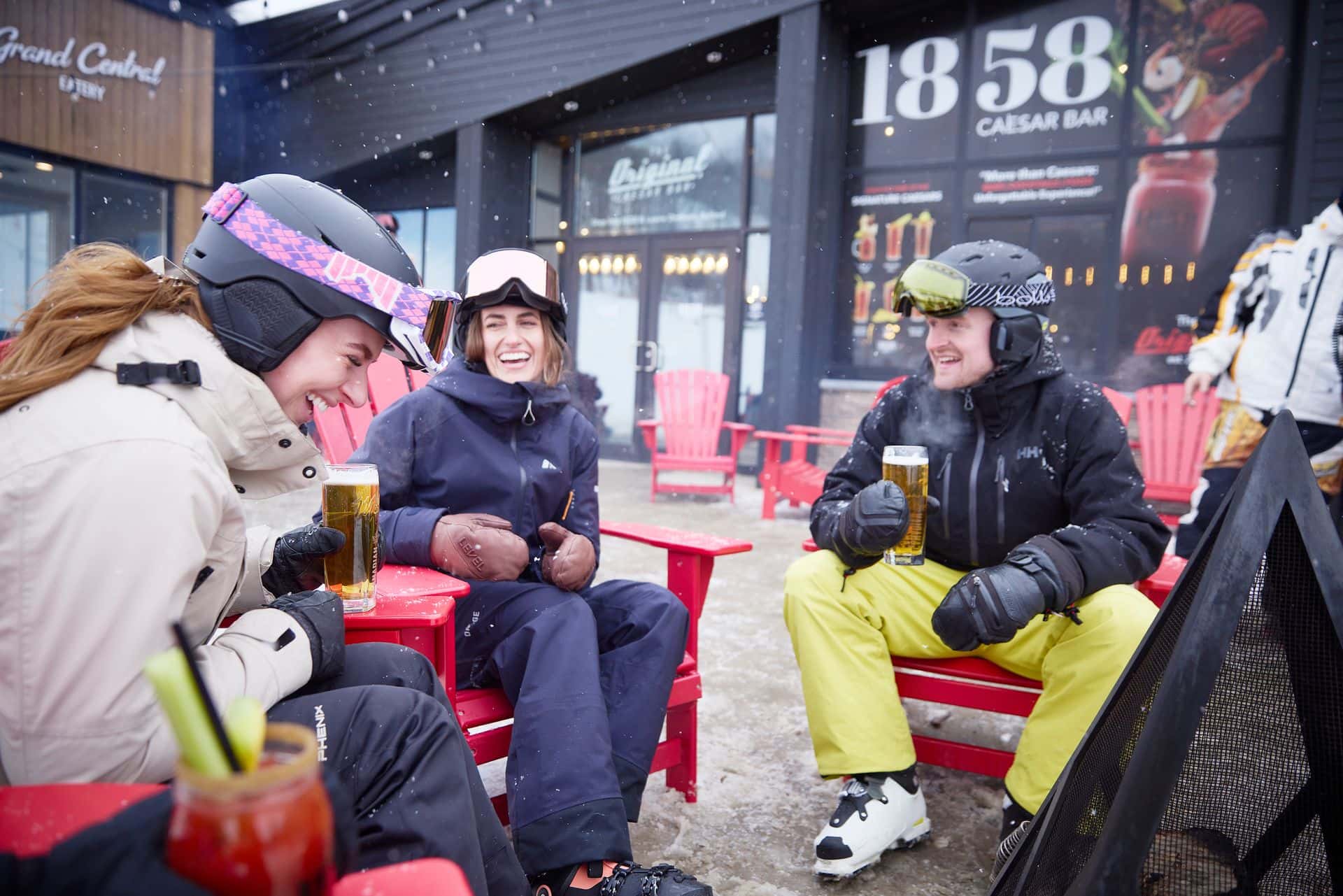 Friends dressed in ski gear, enjoying Après beers and caesars on the outdoor patio at 1858 Caesar Bar 