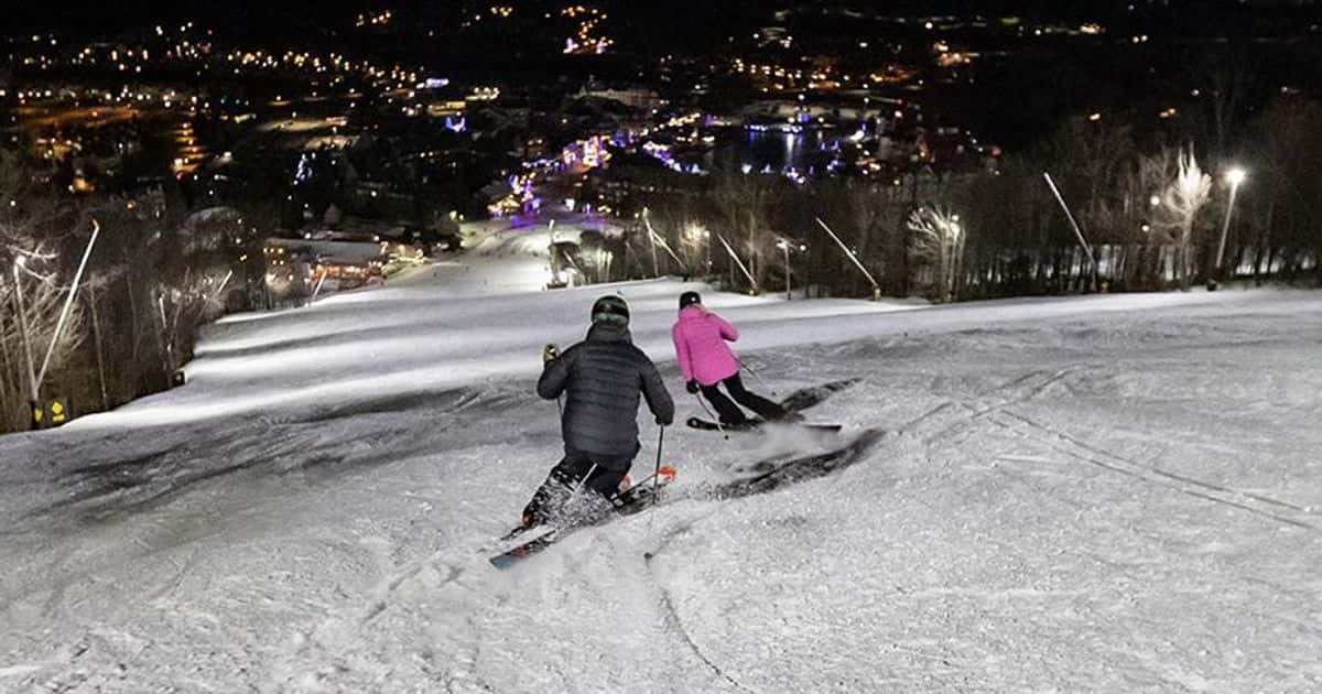 Two skiiers racing down the slopes for midweek night skiing at Blue.