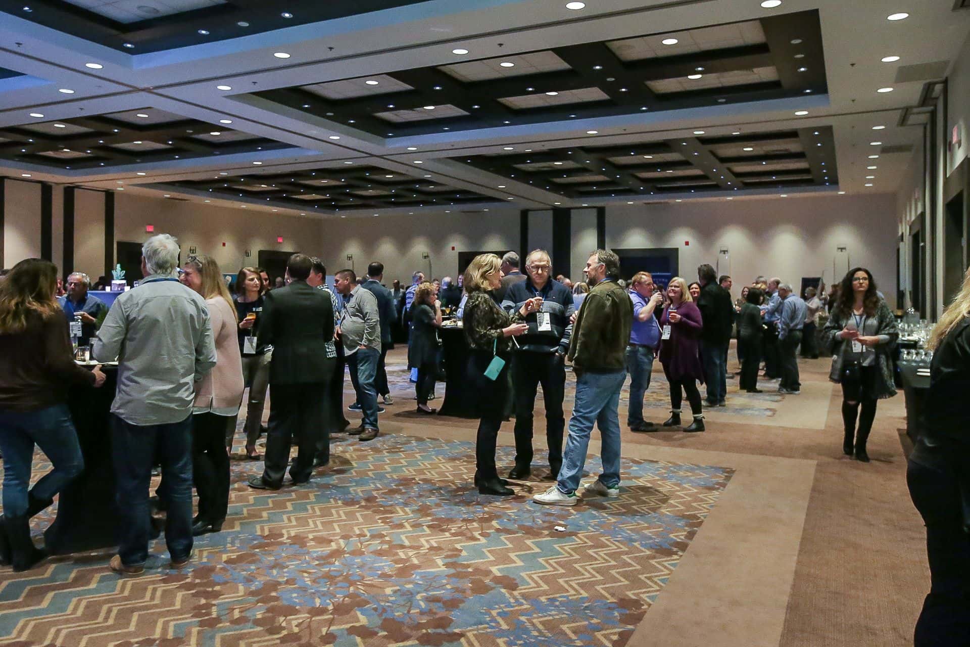 A photo of a room of people networking at a conference. 