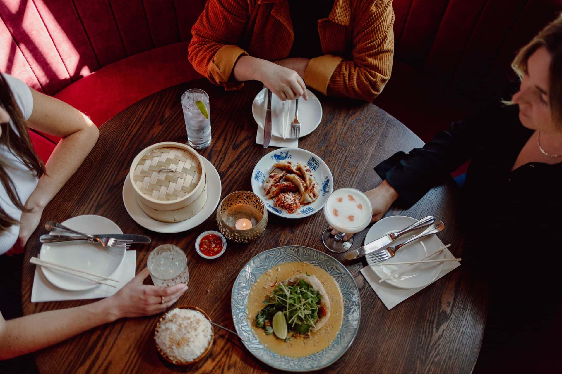 An overhead shot of three visitors dining at Mother Tongue restaurant. 
