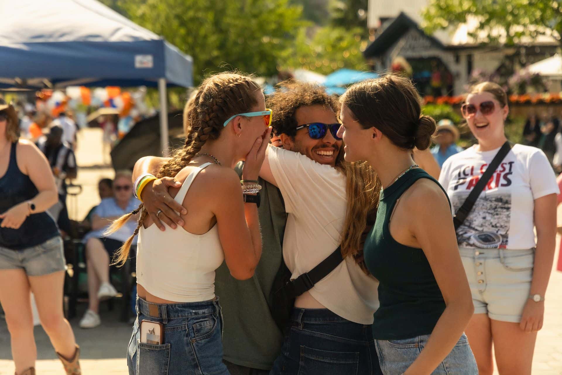 Group of friends hugging and reconnecting the in Village Events Plaza