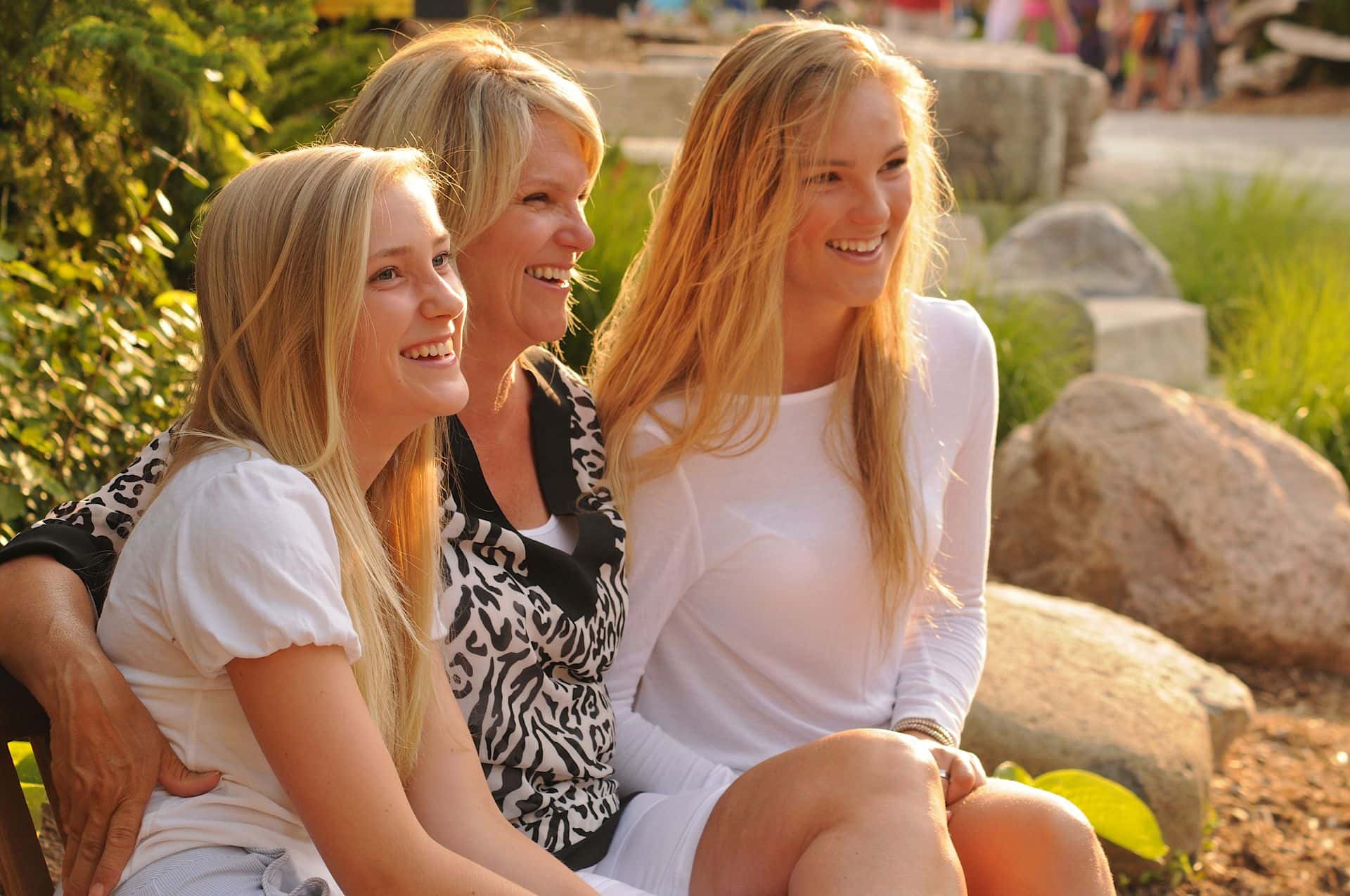 A mom and her two daughters laughing together on a sunny day at Blue Mountain Village.