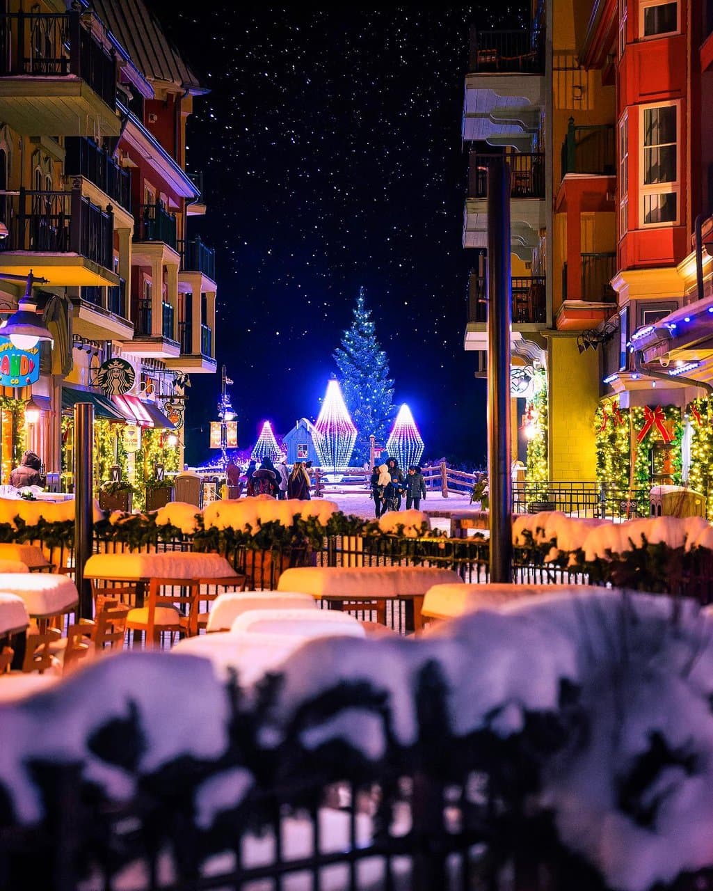 Beauty shot of Main Street in the Village, covered in snow and radiating with festive lights and Holiday decor.