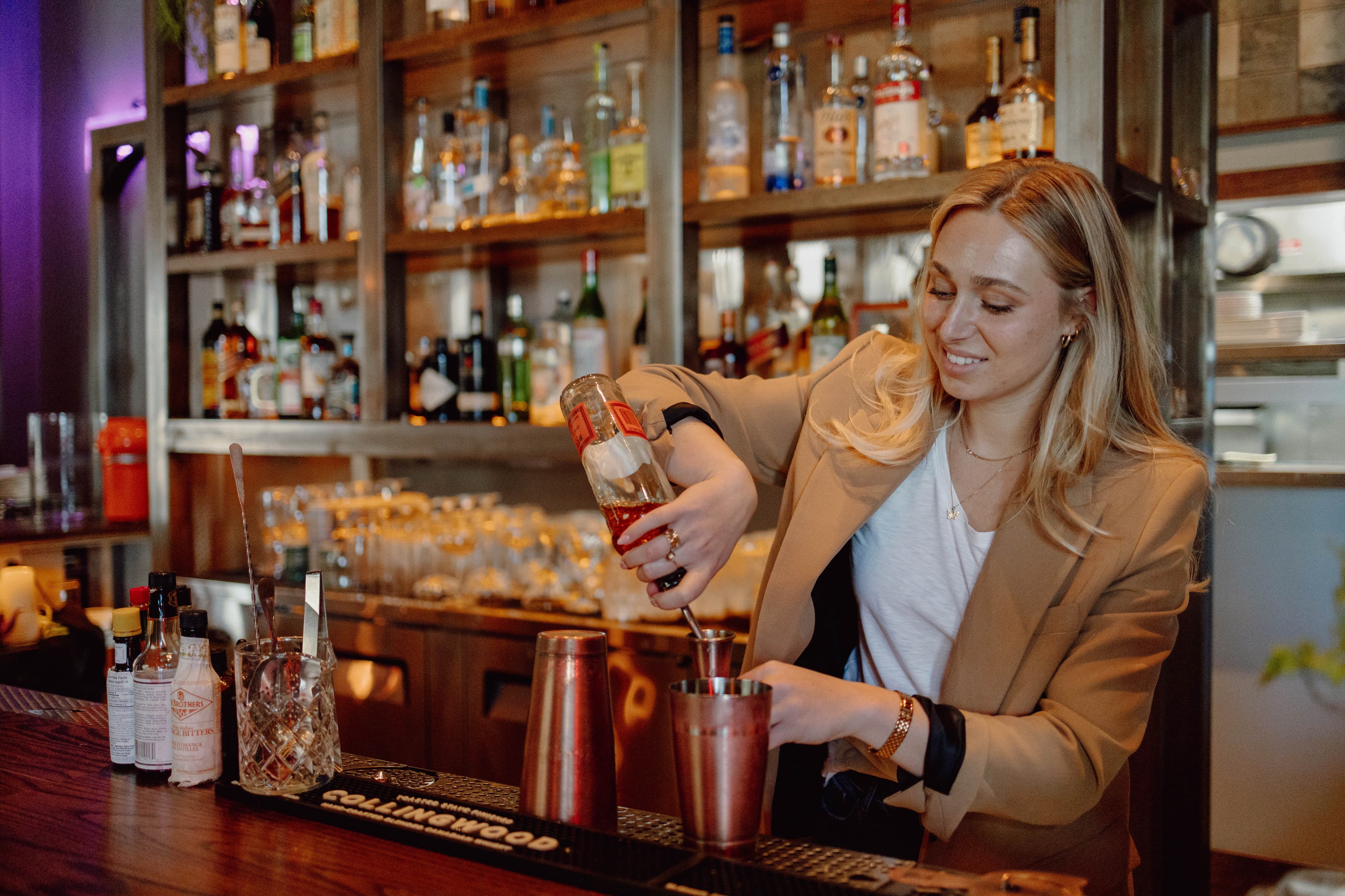 Twist bartender making a cocktail behind the bar.