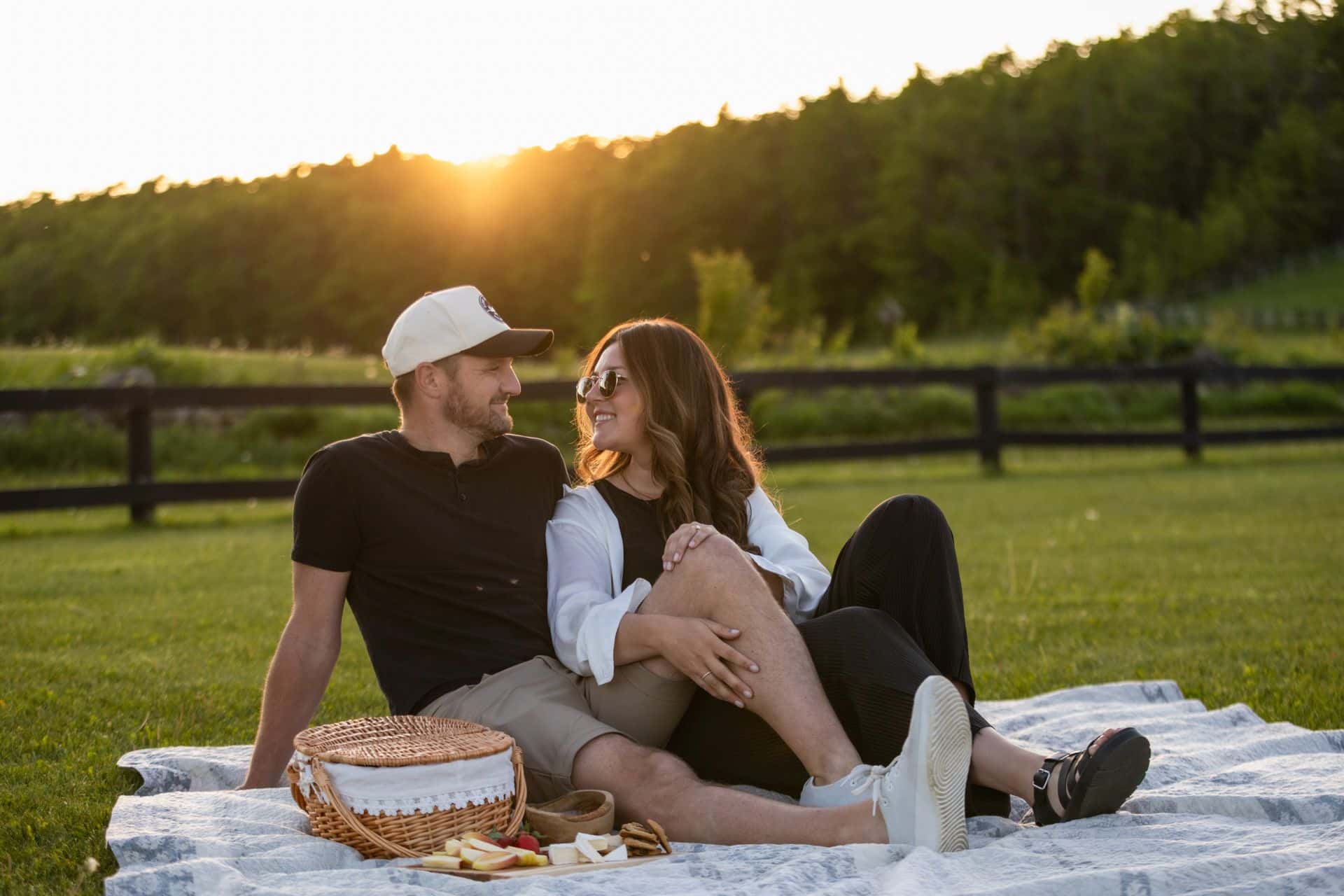 A couple gazing into each other's eyes as they enjoy a curated picnic at sunset at Valley Ridge Family Farm, part of the Apple Pie Trail in the Blue Mountains.