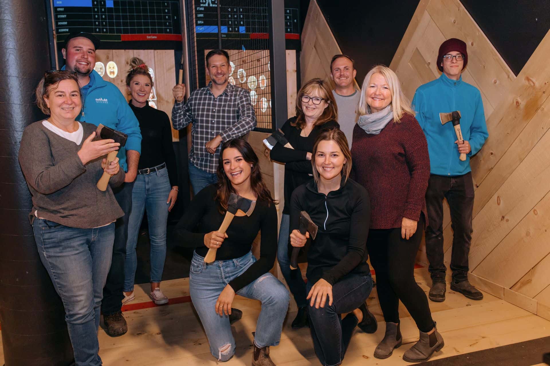 A corporate group smiles for a photo at AXED Throwing in the Village.