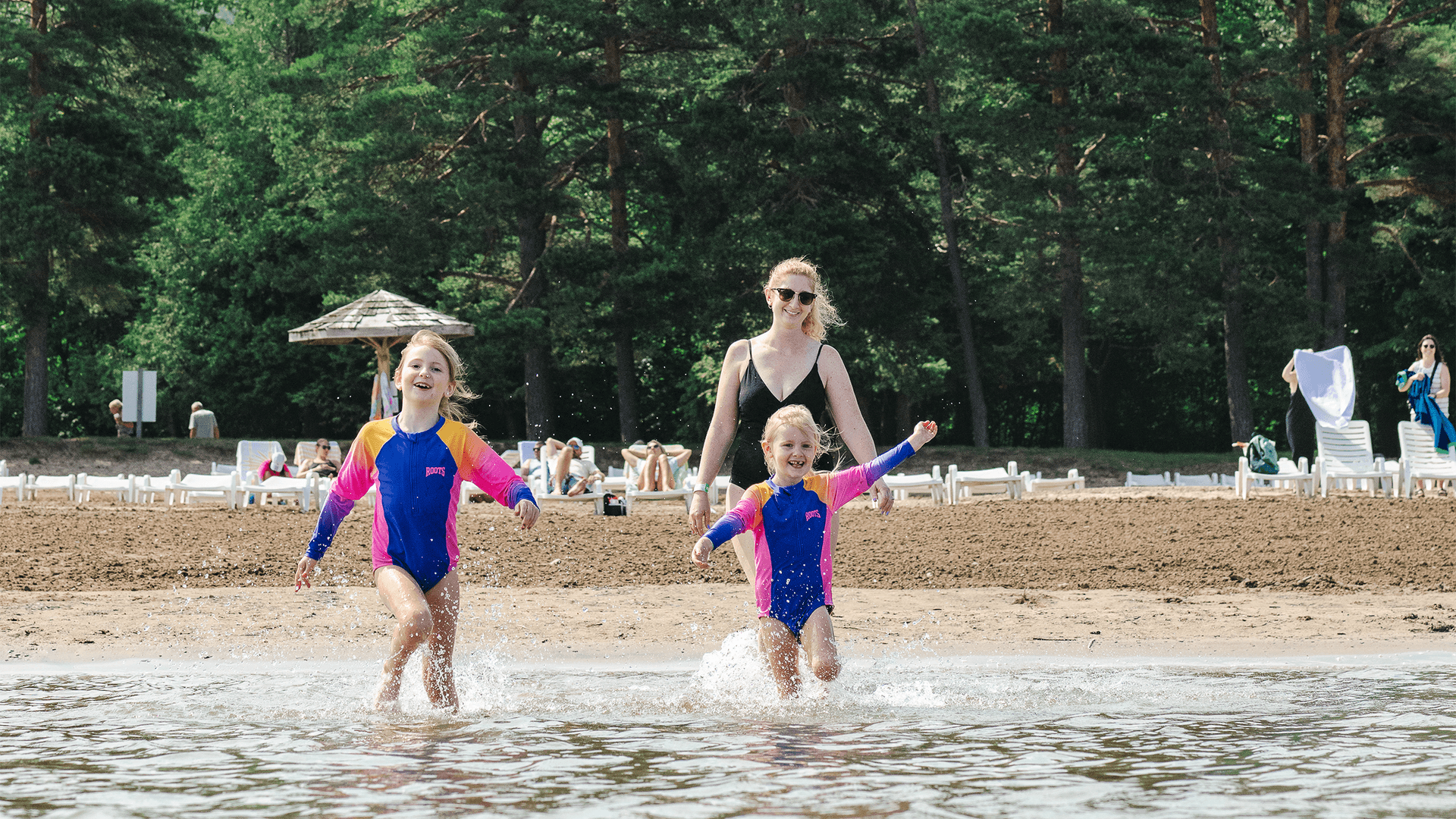 A mom and her two young girls splashing in South Georgian Bay on a Summer day at the Blue Mountain Resort Private Beach.