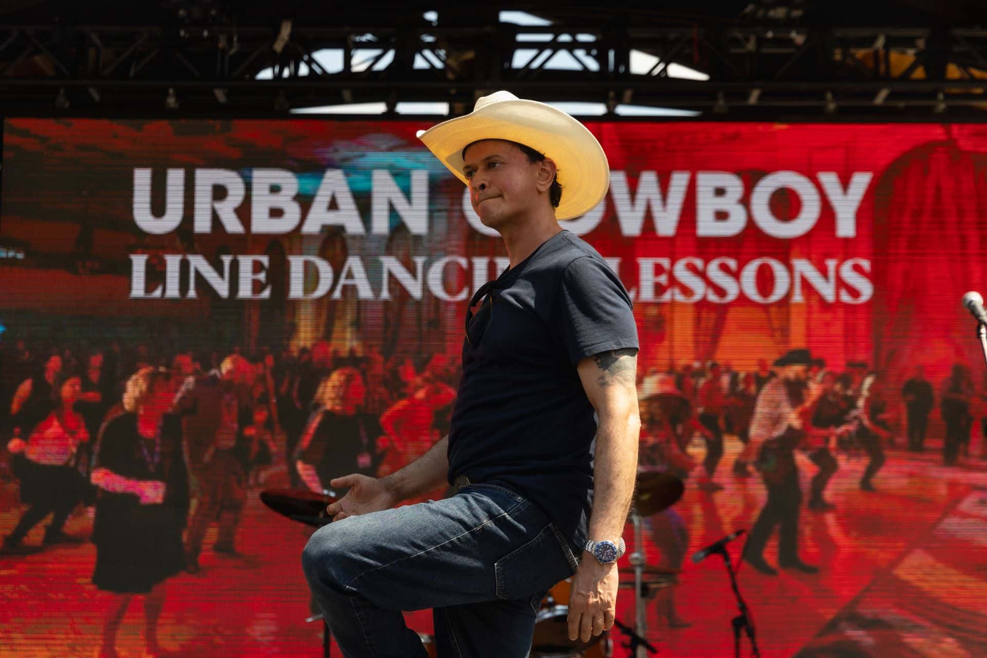 Instructor leading the Urban Cowboy Line Dancing on the Subaru Stage during Country Fest weekend.
