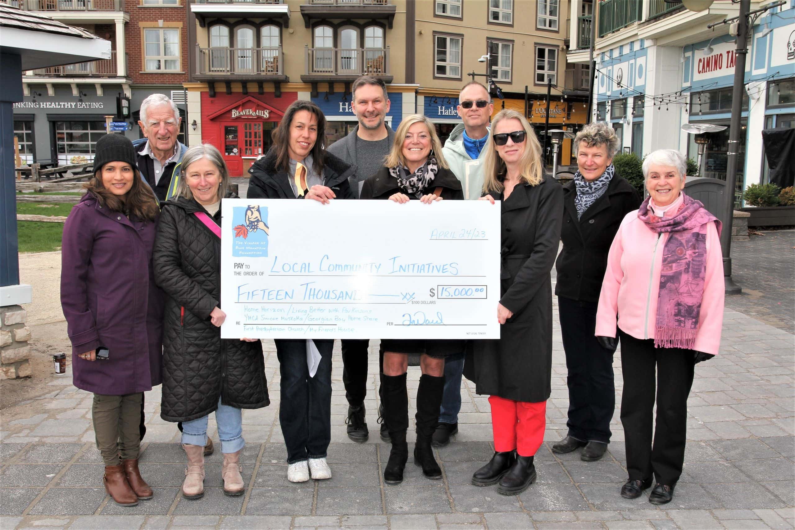 A group of recipients receive a cheque from the BMVF.