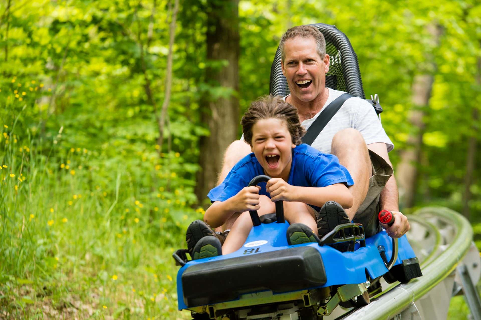 A father and son are excited to ride the ridge runner in summer.