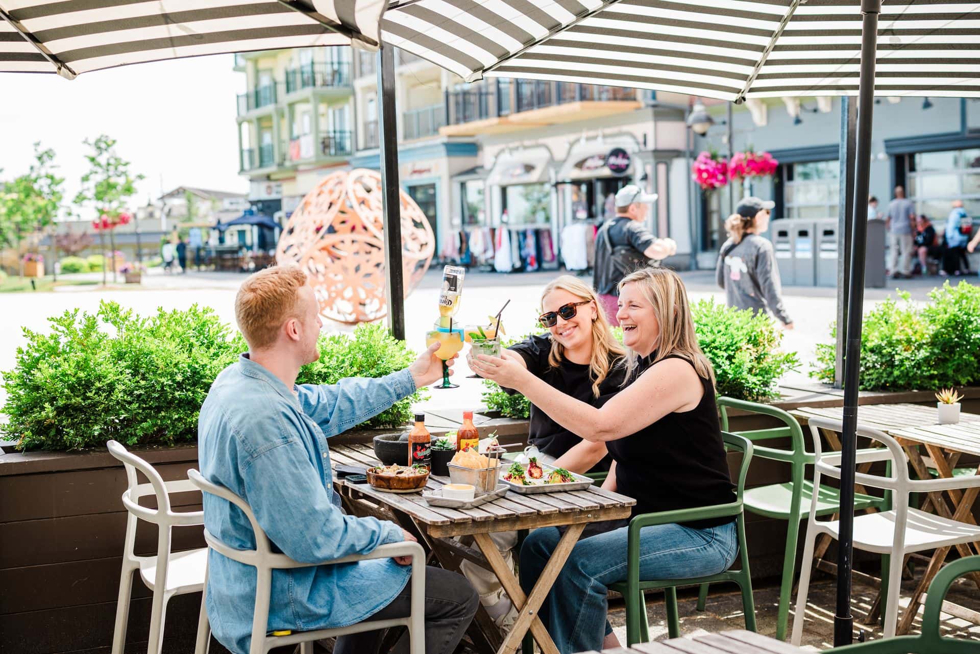 A group clinking together their beverages on the sunny patio at Camino Taco at Blue Mountain Village