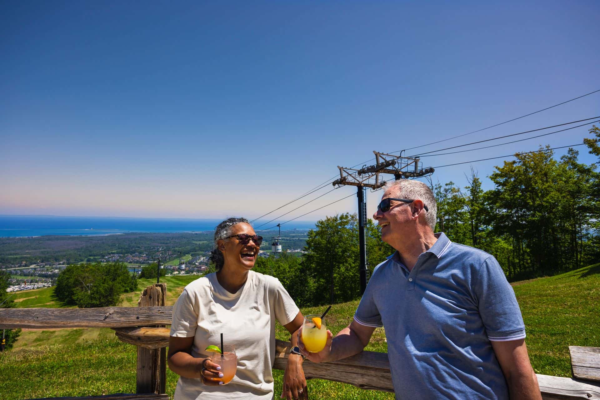 A couple enjoying fresh cocktails overlooking stunning views of the Mountain and Georgian Bay from Summitview Pavillion.