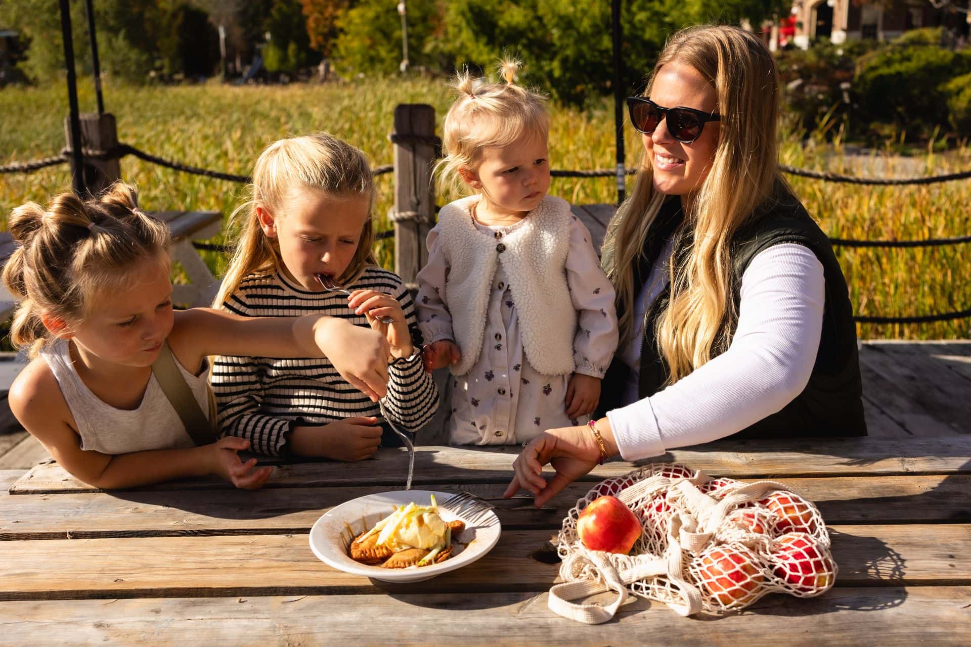 A mom and her three daughters enjoying a taste of apple country with fresh made apple pie while sitting out on the sunny Kaytoo patio on a sunny Fall afternoon.