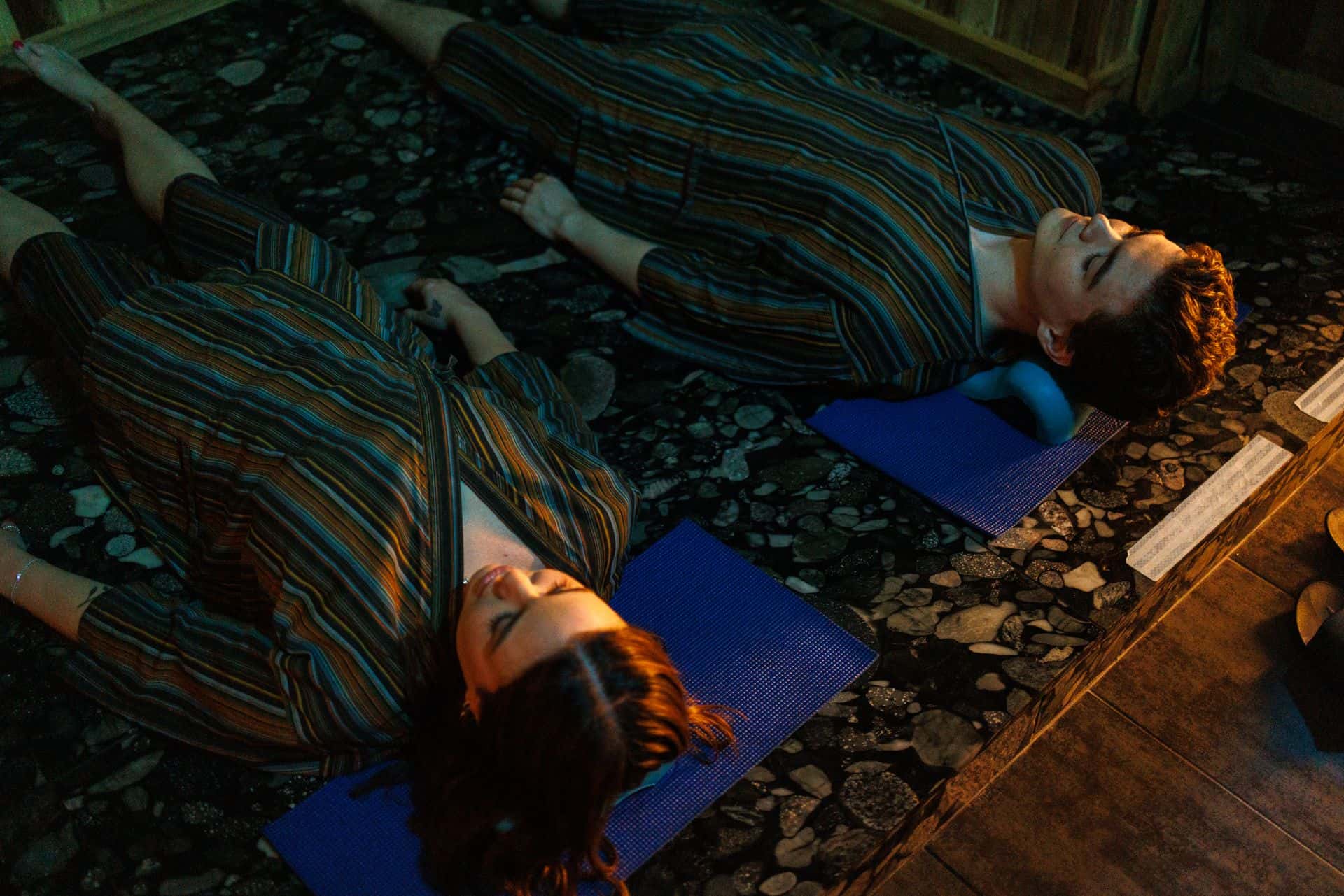 Couple at iwa Spa, laying on the heated volcanic hot rock for restorative yoga after their massage.