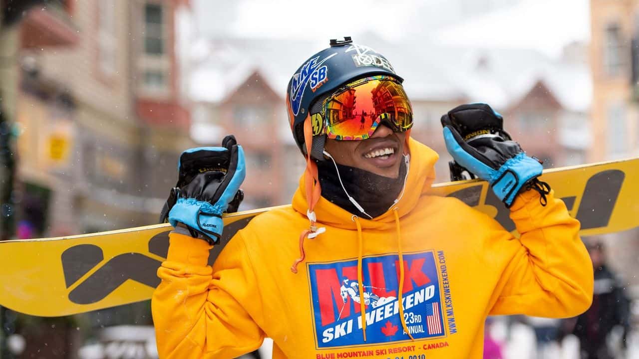 A MLK Ski Weekend snowboarder poses for a photo in the village.