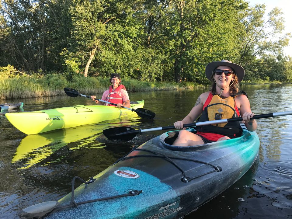 Two friends paddling down the Beaver River with Free Spirit Tours Kayaking on a warm Summer evening