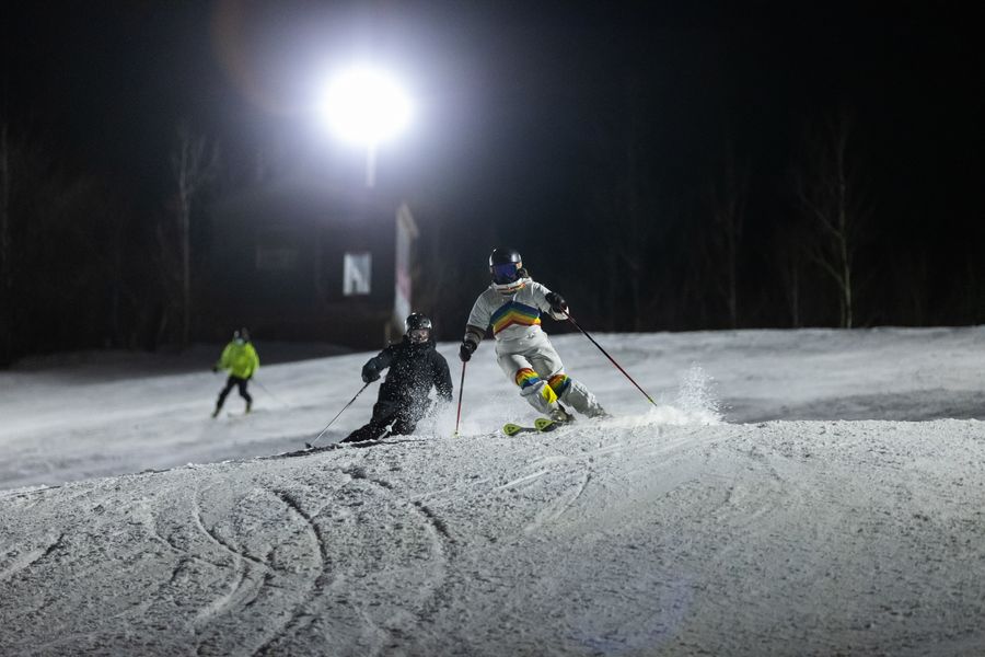 Skiiers racing down the mountain at night