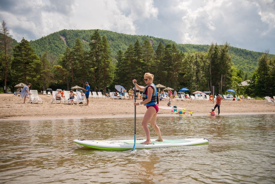 Woman paddling across the Blue Mountain Private Beach on a stand up paddle board.