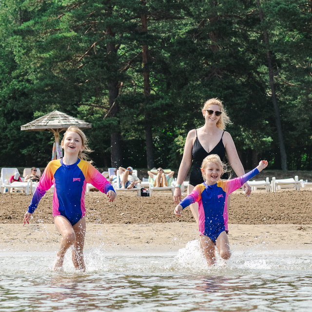 A mom and her two young girls splashing in South Georgian Bay on a Summer day at the Blue Mountain Resort Private Beach.
