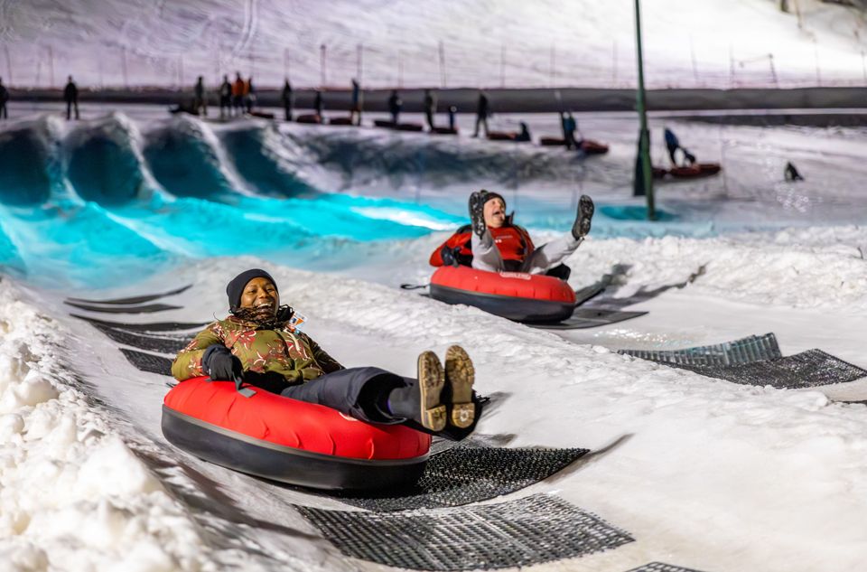 Two friends racing down the Big Dipper Snow Tubing lanes on a Winter's night.