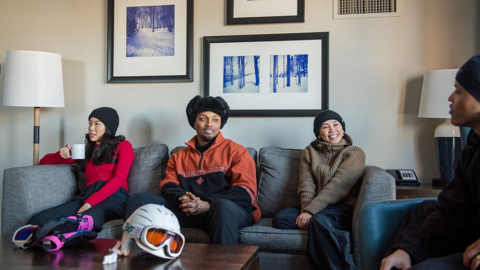 Group of friends relaxing on the couch after a day of skiing in their Weider Lodge suite. 
