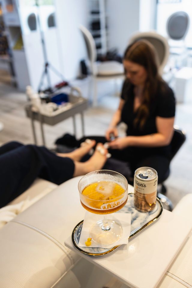 Sip and soak at Beauty Bar by iwa. Enjoy crisp cocktails and signature waterless pedicures.