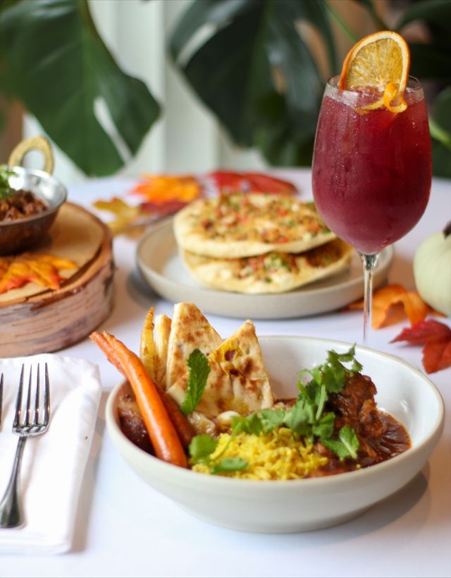 A beautiful table of fall-inspired dishes prepared specially for Fallicious 2025 at Oliver and Bonacini cafe grill. The table is decorated with fall leaves and pumpkins for seasonal affect.