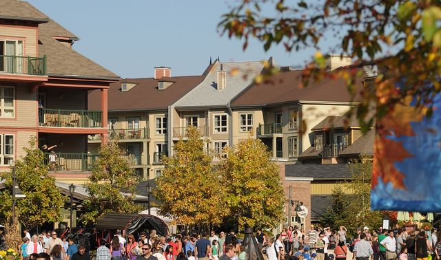 A beautiful view of a sun-kissed Village on a crisp fall afternoon with lots of guests wandering around the events plaza.