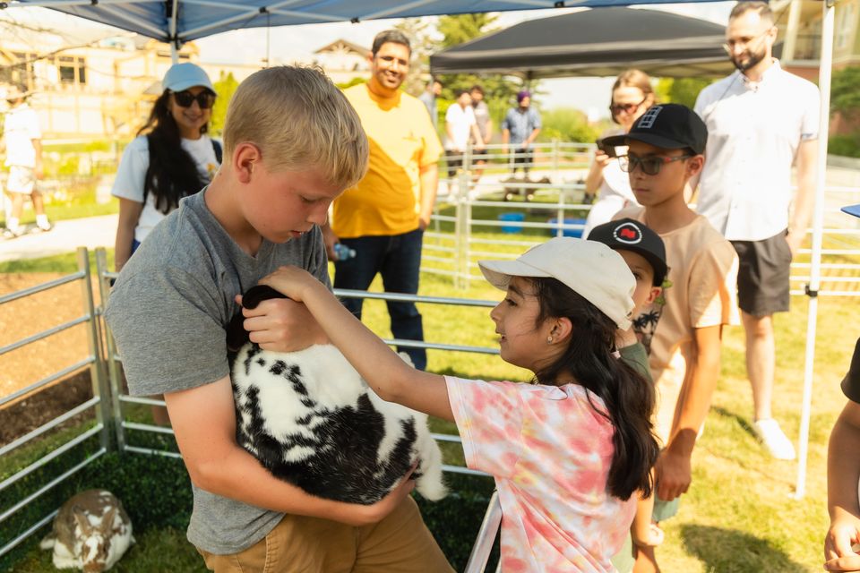 Young girl petting a rabbit at the Barnyard Bonanza in the Village, brought to you by Valley Ridge Family Farm