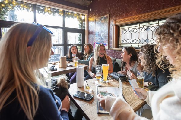 Large group of girls crying laughing over cocktails at MJ Byrne's Irish Pub