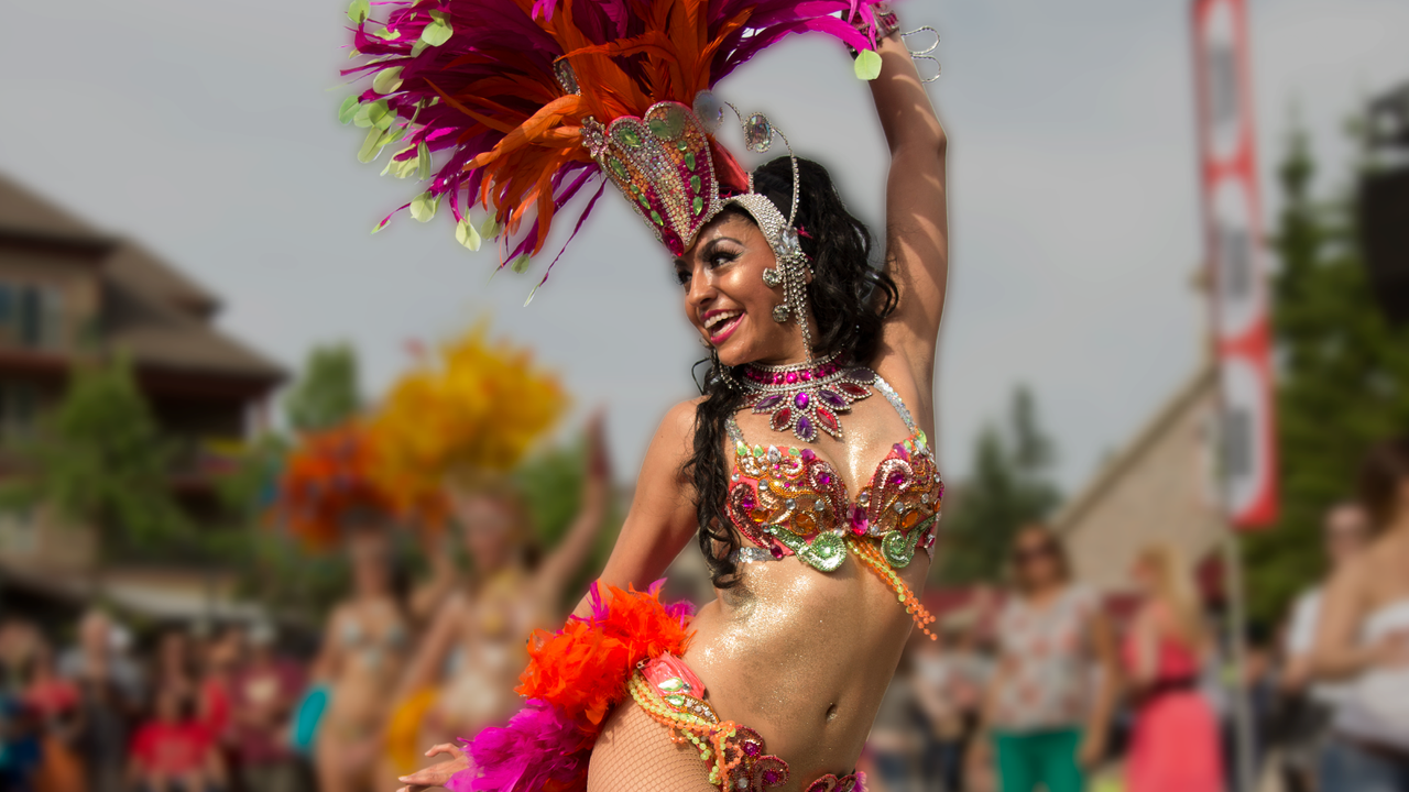 Latin dancer dressed in bedazzled bikini and traditional headdress, performing live at Salsa at Blue.