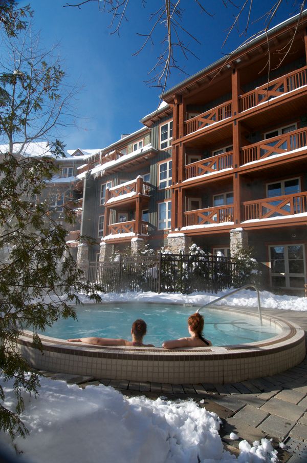 A couple soaks in the outdoor hot tub at Weider Lodge during a Winter afternoon.
