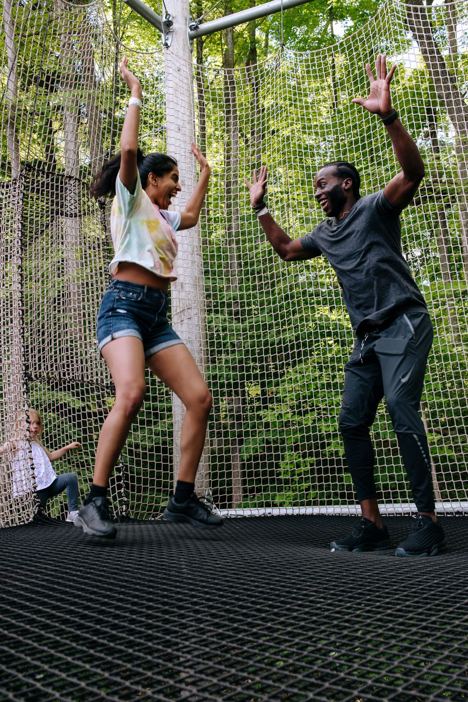 A couple bouncing up from the trampoline floors of the canopy climb adventure in the Blue Mountain Resort Adventure Park.