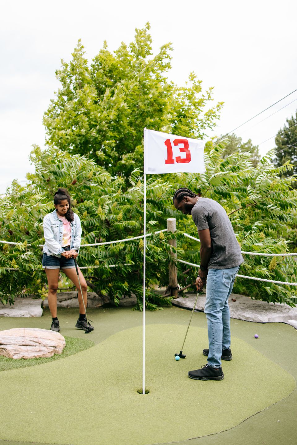 A couple competes against each other in a friendly game of mini putt at the Cascade Mini Putting Course at the base of Blue Mountain