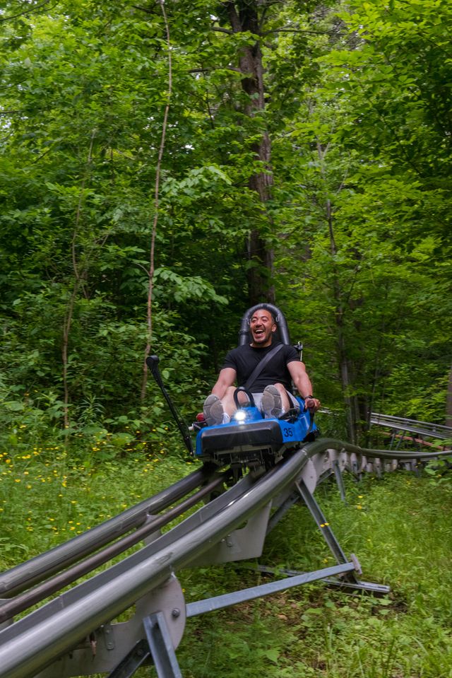 A man screaming with excitement as he races down the Ridge Runner Mountain Coaster at Blue Mountain Resort.