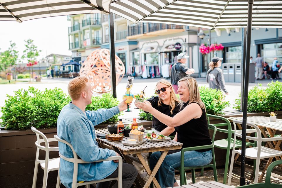 A group clinking together their beverages on the sunny patio at Camino Taco at Blue Mountain Village