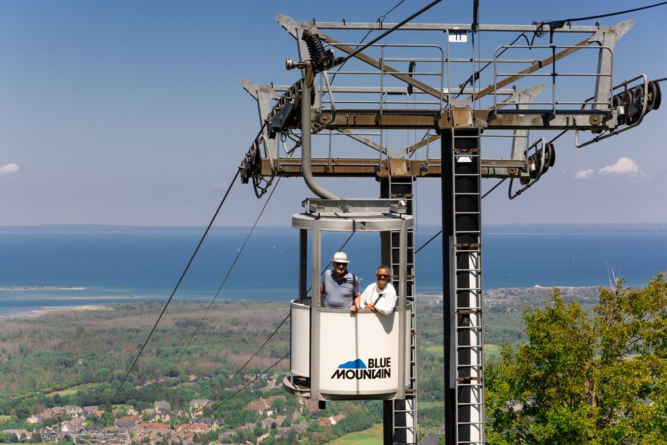 A mature couple gazes out across the stunning view from Ontario's only Open-Air Gondola at Blue Mountain Village.