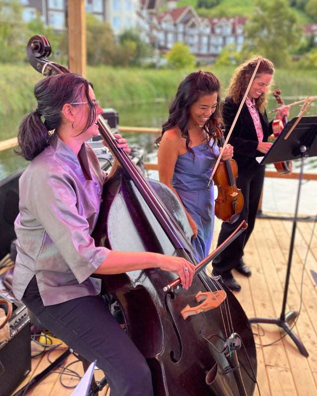 A close up of three members of the Toronto Concert Orchestra performing on the Floating Stage for Symphony on the Pond at Blue Mountain Village.