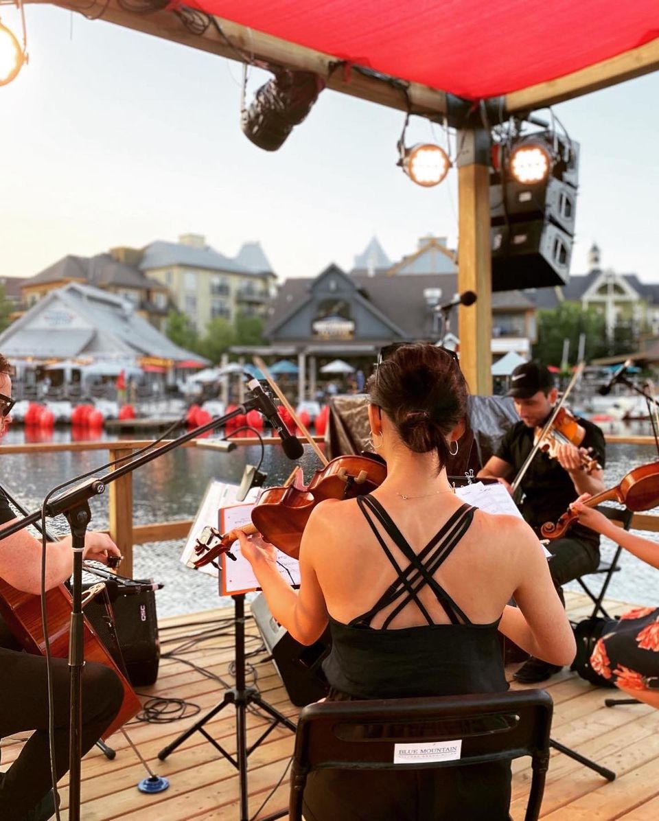 The Toronto String Quartet performing on the Floating Stage at sunset for symphony on the pond during a summer evening at Blue Mountain Village.