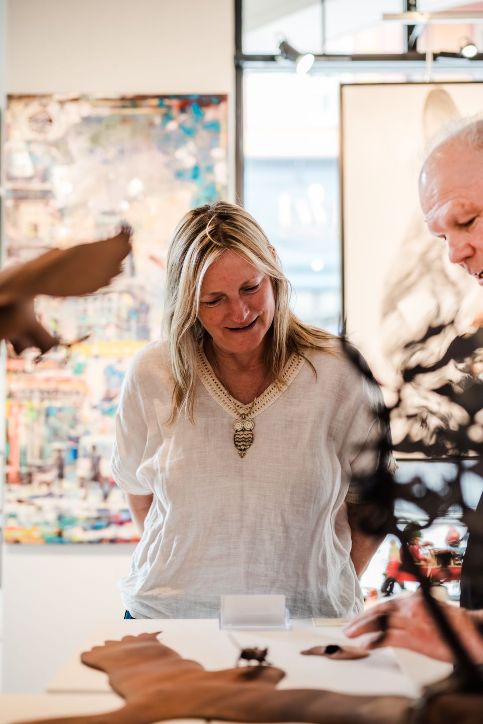 Woman learning about the Canadian Artists with sculptures at Bright's Gallery in the Village