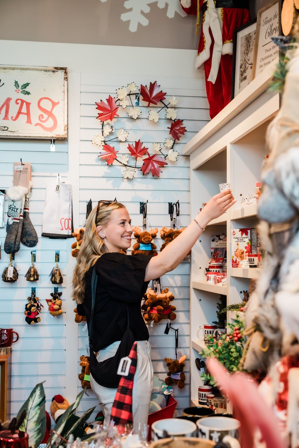 A young lady perusing through Canadian inspired home decor at Georgian Christmas shop in Blue Mountain Village
