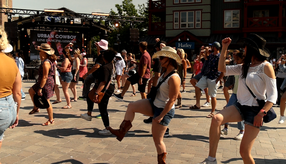 A full plaza of people dressed in their Southern best for Urban Cowboy Line Dancing lessons at Blue Mountain Village