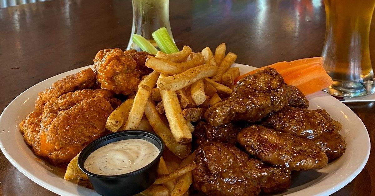 A plate of wings, fries, and pints of draught beer served at Wild Wing at Blue Mountain Village
