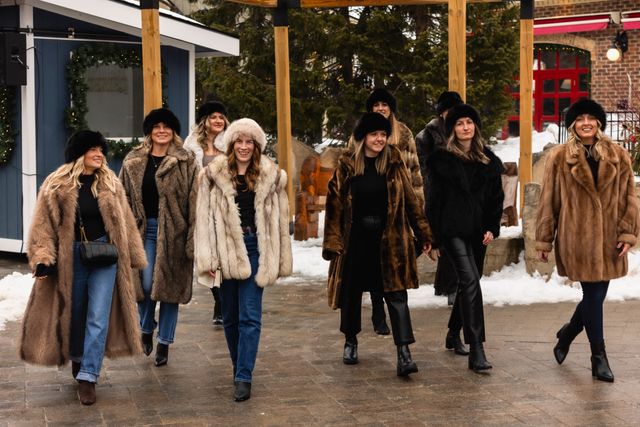 A group of girlfriends walking through the Village plaza, all dressed in fur coats and hats as they head out for Après Ski festivities at Blue Mountain.