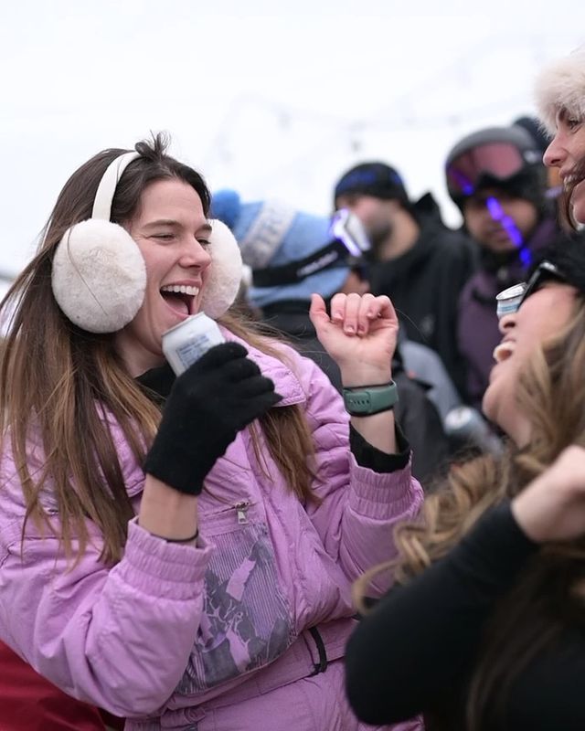 Girls dressed in winter Apres attire, dancing with drinks in hand on Kaytoo's patio during the Aftrglow Festival in 2025