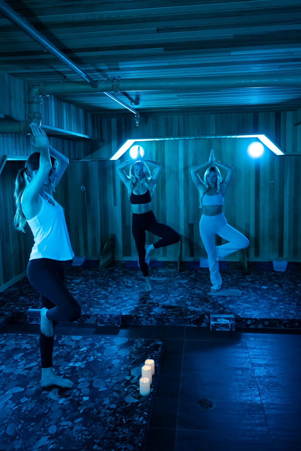 Two girlfriends follow along with the yoga instructor during a restorative session in the iconic Volcanic Rock studio at iwa Spa in Blue Mountain Village.